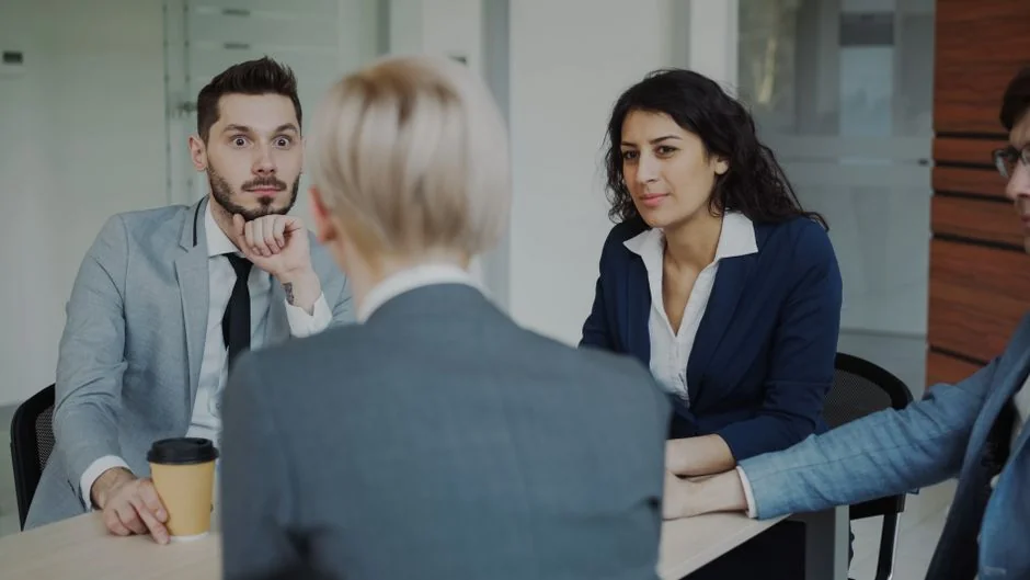Une équipe diversifiée collabore autour de stratégies de marketing numérique à une table, avec des ordinateurs portables et des tablettes.