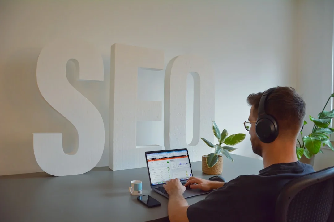 Un espace de travail moderne où des mains examinent des données marketing sur un ordinateur portable et des documents papier.